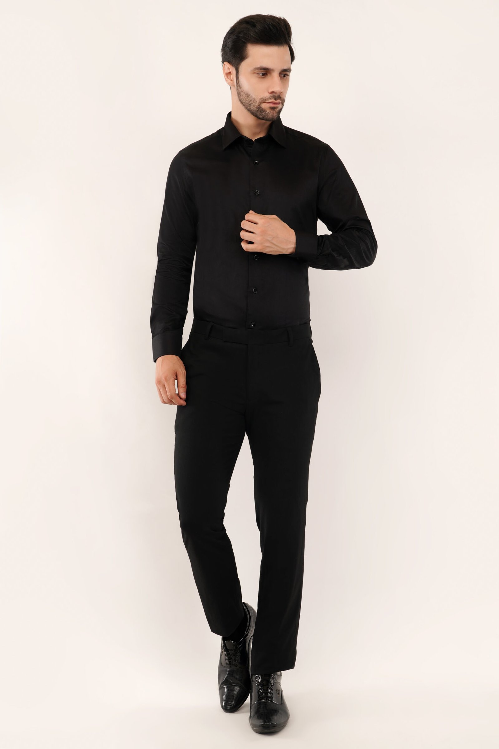 Model wearing a sleek black shirt, showcasing a modern fit and premium cotton fabric for men.